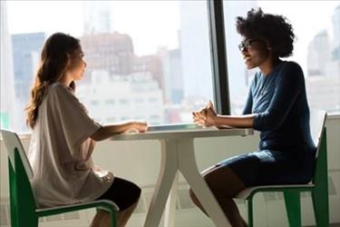 an employee and her manager having a one on one meeting