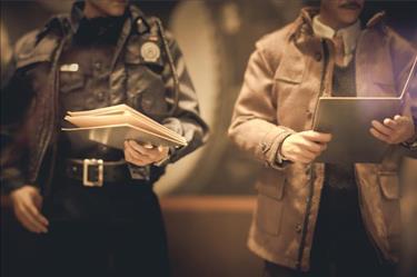 Police officer and law enforcement colleague reviewing files