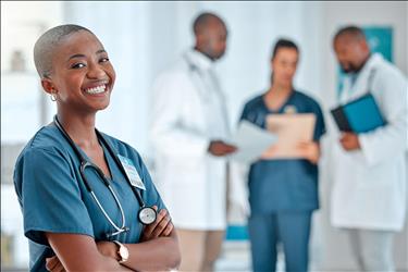 happy healthcare employee with her team in the background