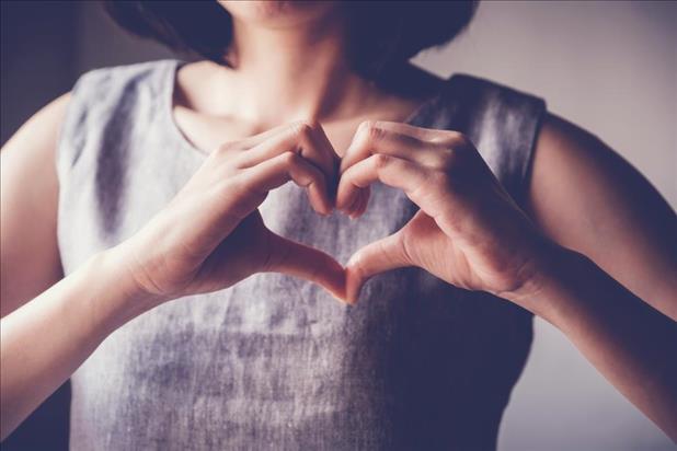 woman making a heart shape with her hands