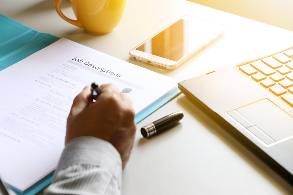 hr professional at his desk reviewing a job description