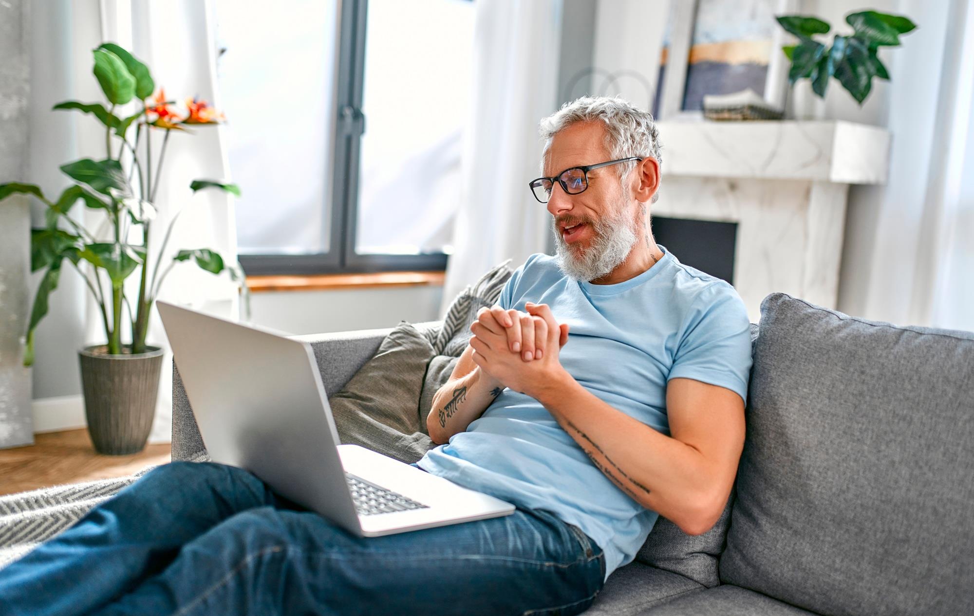 remote worker in a virtual meeting on his couch