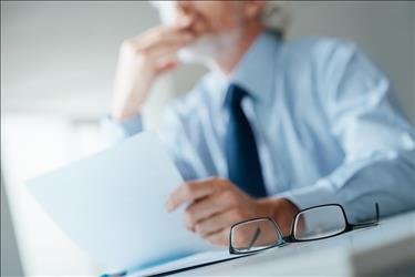 optometrist at his desk with a letter dismissing a patient