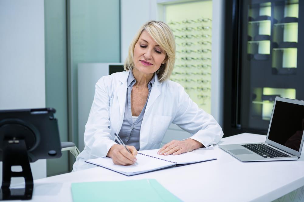 optometrist writing a letter dismissing a patient