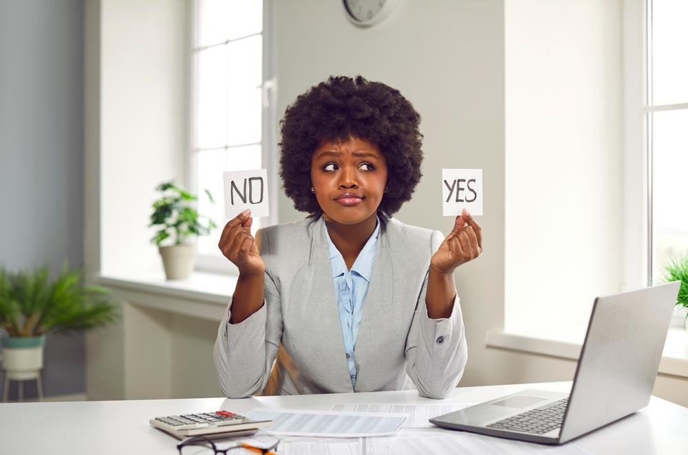 woman holding pieces of paper that say yes and no in each hand