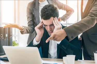 Man stressing while two people give him instructions