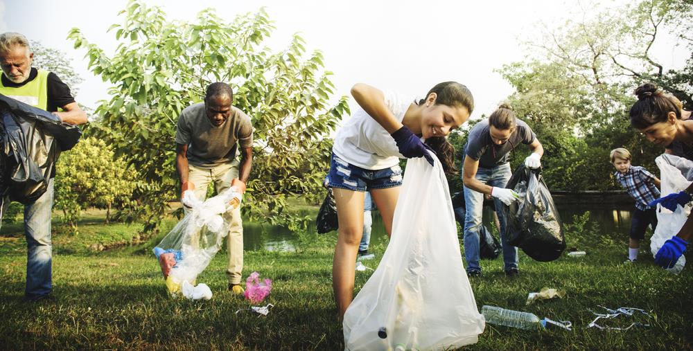 group of employees volunteering to pick up trash at a park