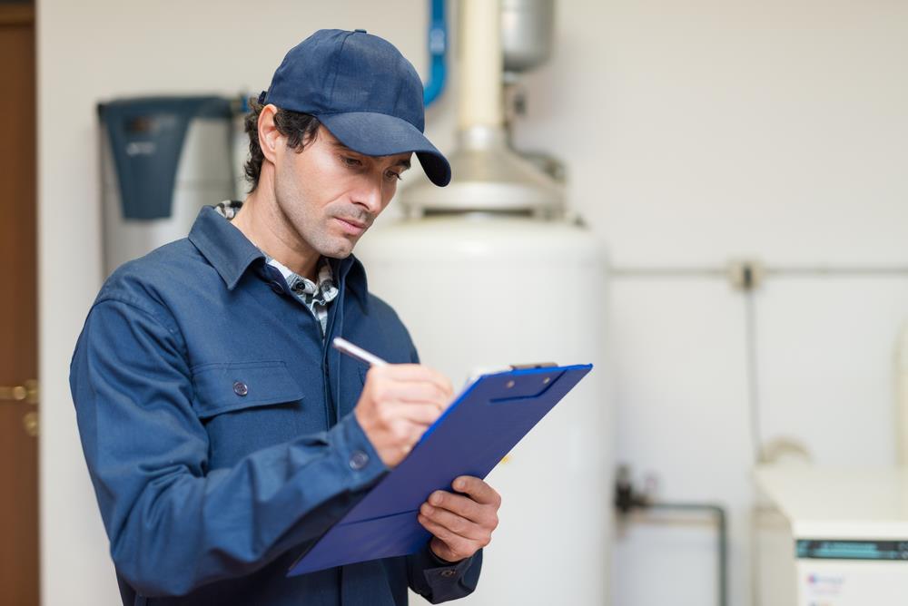 male maintenance technician servicing a water heater