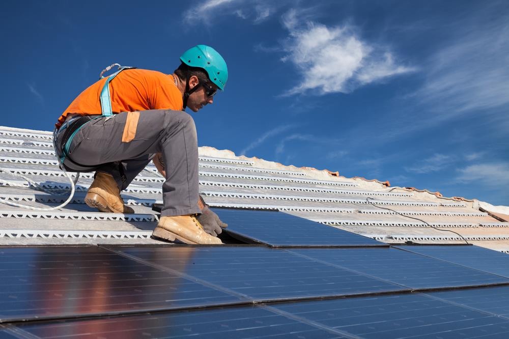 solar photovoltaic installer working on a rooftop