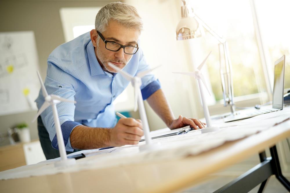 male green building architect working on plans at his office