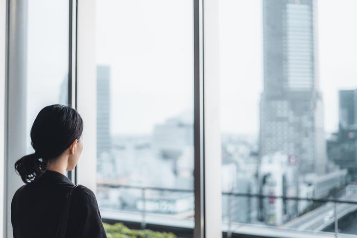 Professional considering a career change while looking out a window