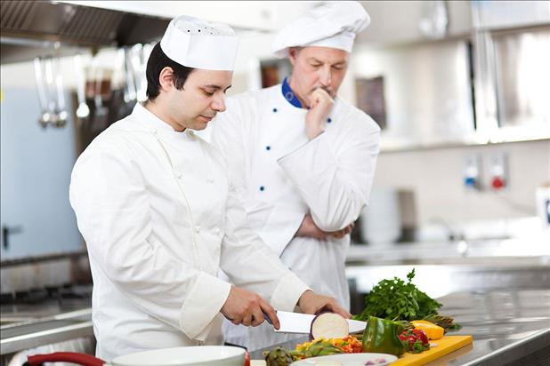 Culinary student training to become a chef and learning knife skills in the kitchen