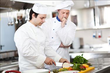 Culinary student training to become a chef and learning knife skills in the kitchen