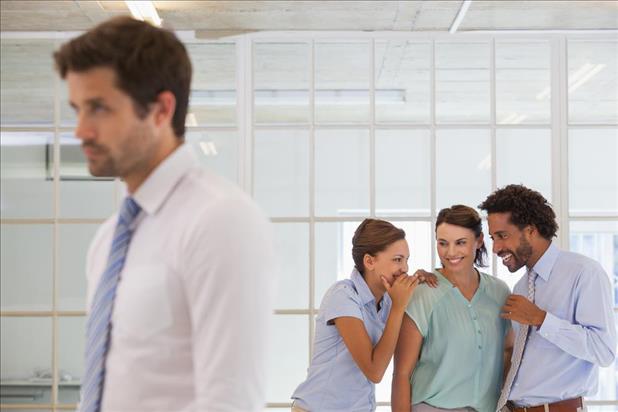 Group of professionals gossiping behind their coworker's back