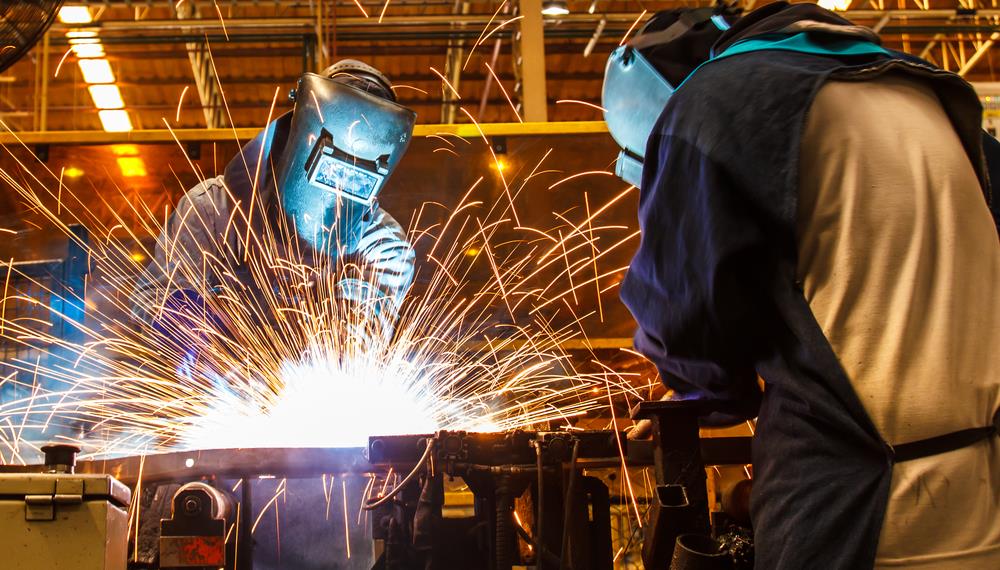 two welders working on equipment