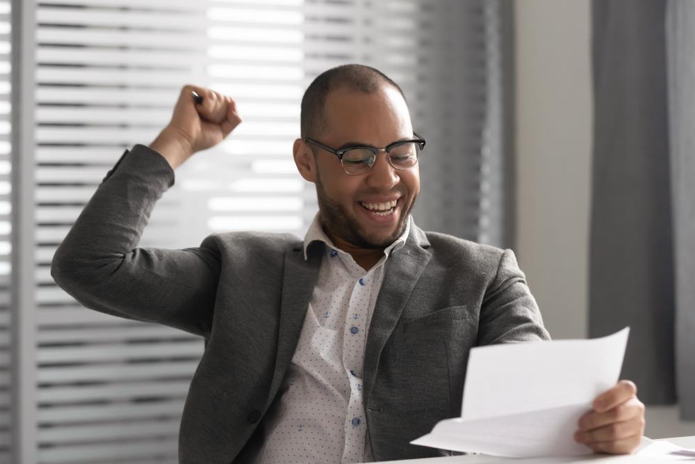 Job seeker celebrating while reading his job offer