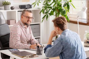 employer interviewing a candidate for a job at a desk