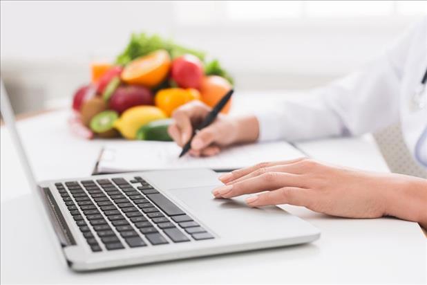 Closeup shot of dietitian writing their resume with fresh fruit in the background