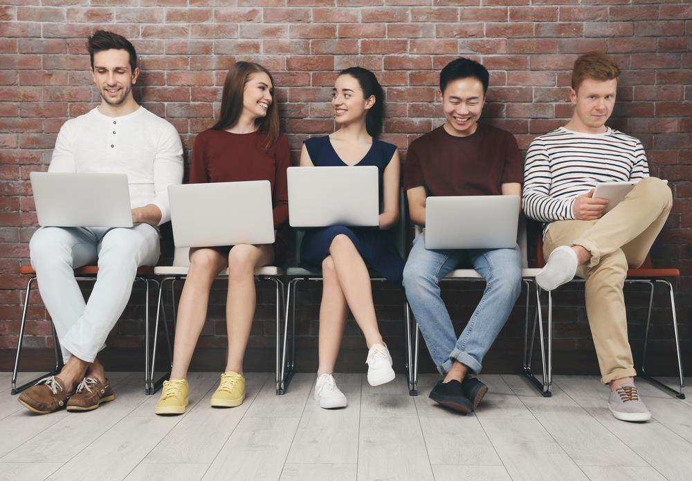 group of new graduates searching for jobs on their devices