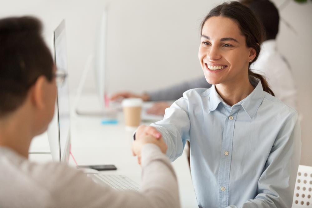 new graduate shaking an employer's hand after a successful interview