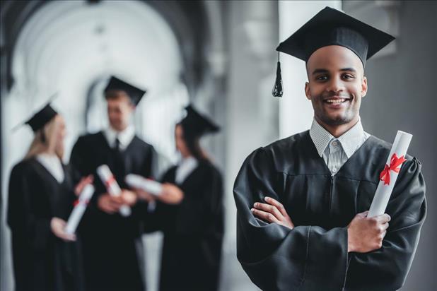 College graduate in robes posing for a photo