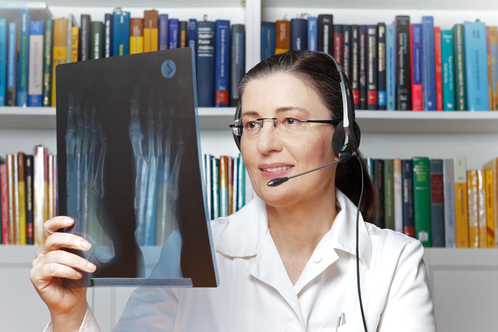 radiologist working remotely on the phone examining x-ray