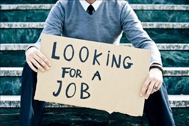 Businessman holding sign that says "Looking for Job"