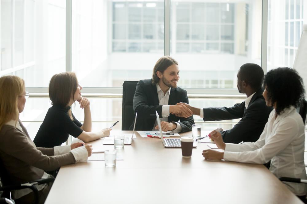 Interviewer introducing himself to candidates in a meeting room