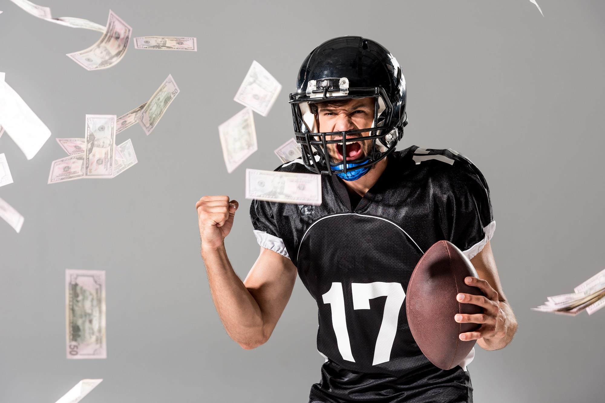 excited football player with money falling around him