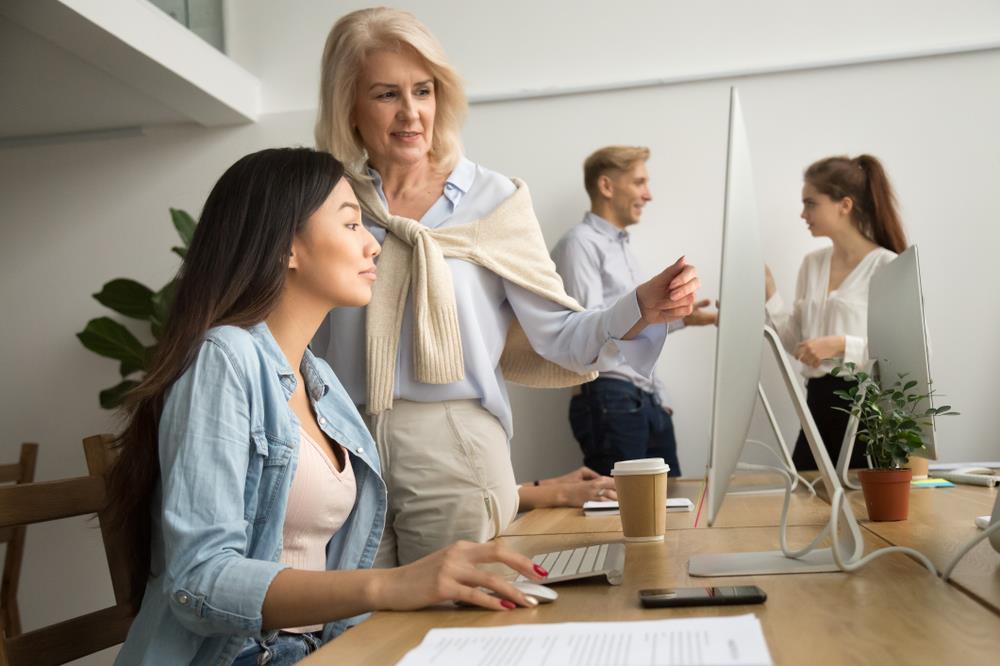 female ceo training an employee at her desk