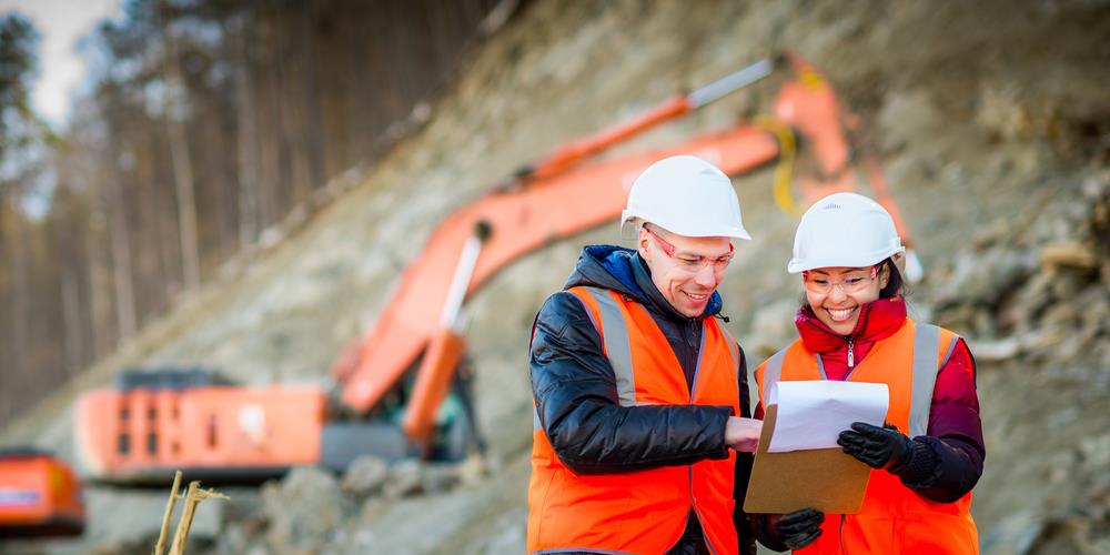 two construction team members reviewing a document on a job site