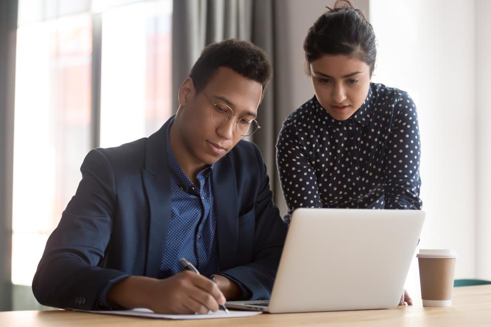 hiring manager working with a teammate on writing a salesperson job ad