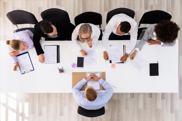 group of employees interviewing a job candidate