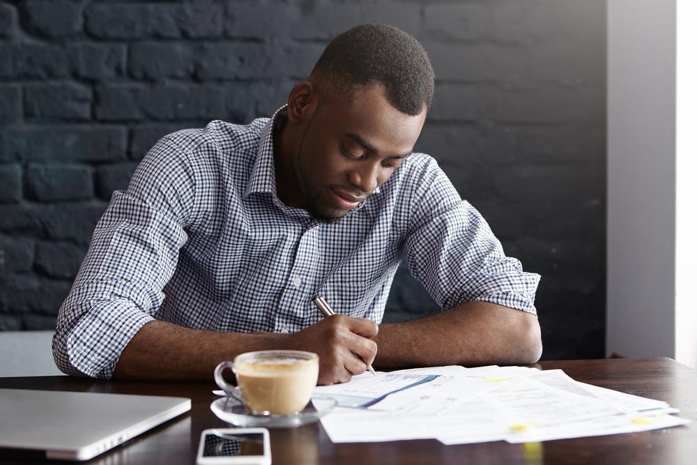 job seeker writing his SSN on employment application for his dream job