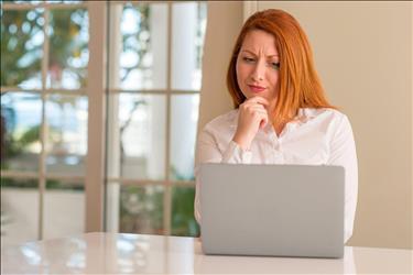 woman looking at her laptop screen in a concerned way