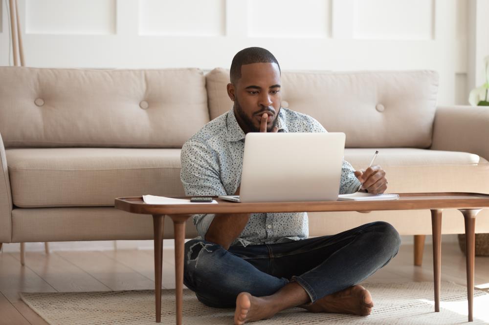 Man researching and taking notes at home