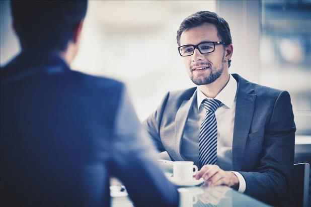 two professionals conducting a job interview over coffee