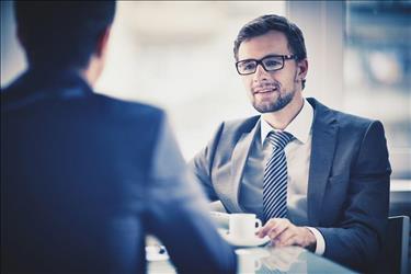 two professionals conducting a job interview over coffee