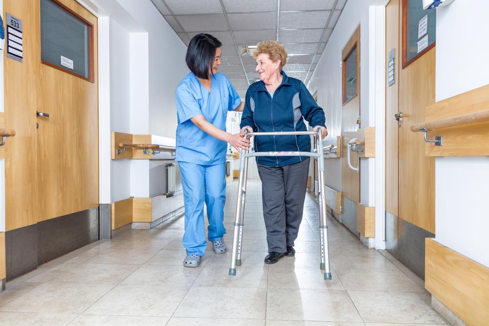 nurse assisting an elderly patient in a hospital hallway