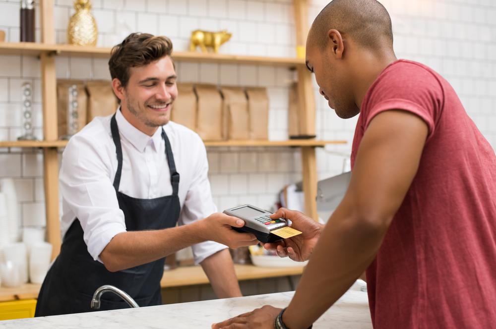 cashier assisting a customer at the counter of a coffee shop