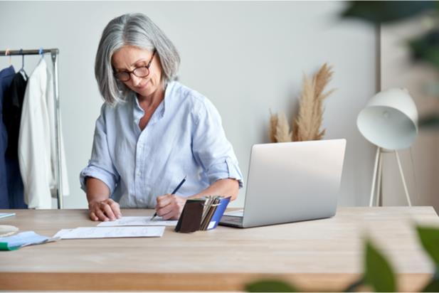 older woman writing at a table