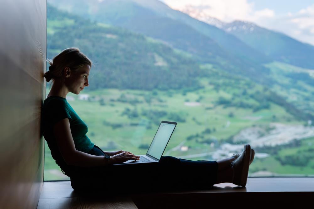 Woman working on laptop in mountains