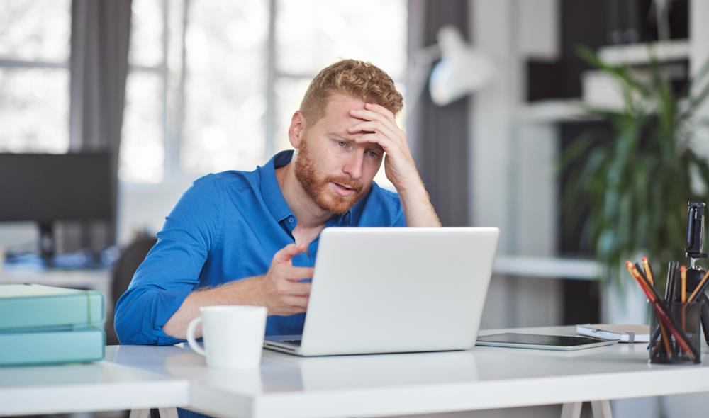 Man unhappy at laptop