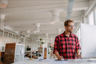 graphic designer at his desk reviewing interview tips online