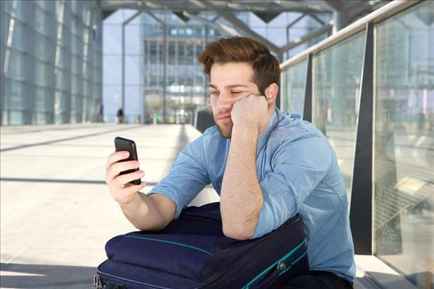 Frustrated man looking at phone, waiting for a call