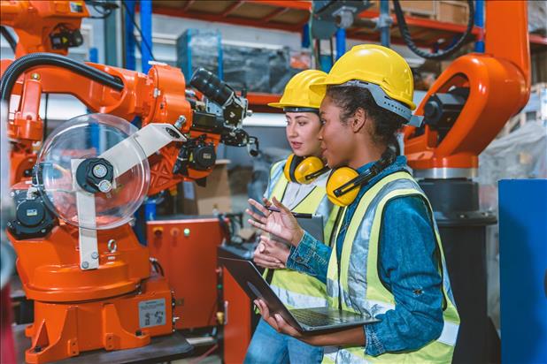 two manufacturing employees working together on a machine