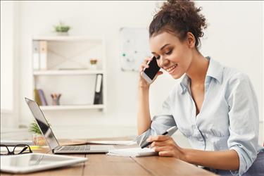 Job seeker taking notes during phone interview