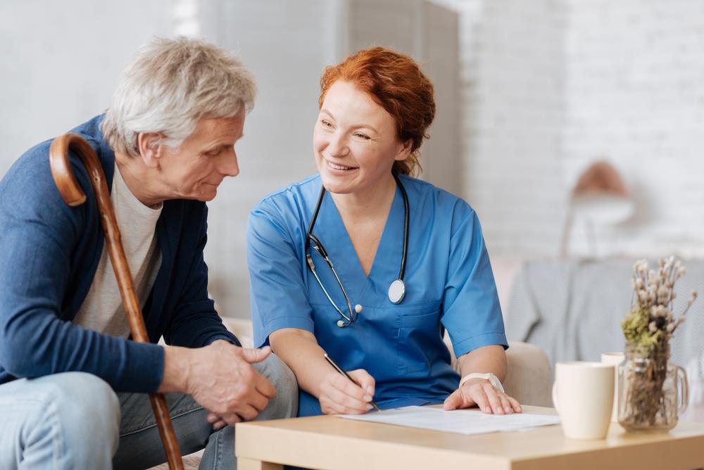 home health aide helping a patient complete paperwork