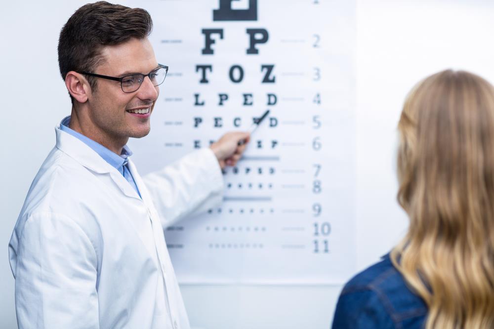 male optometrist running a vision test on an adult patient