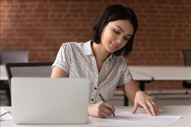 job seeker taking notes while preparing for an interview